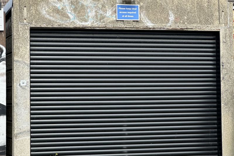 modern black roller garage door with access sign gillin